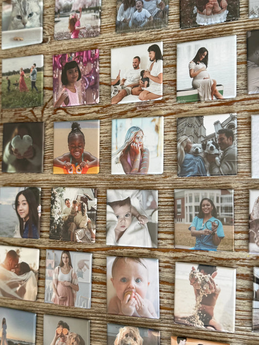 A collection of custom photo magnets neatly displayed on a wooden surface.