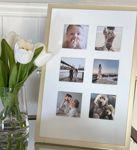 Six square custom magnets on a white frame with gold trim, styled beside a vase of white tulips on a mirrored wooden table.